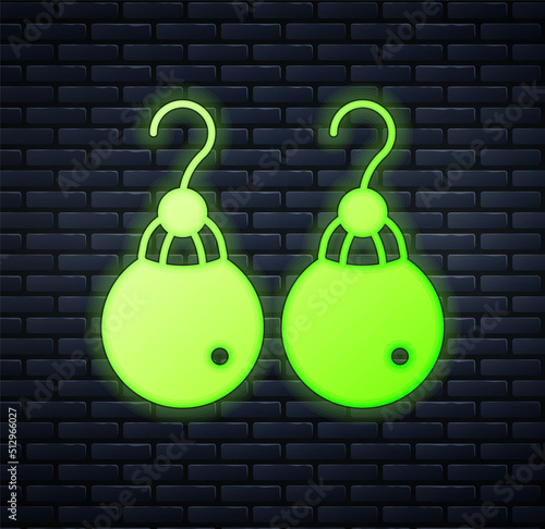 Glowing neon Earrings icon isolated on brick wall background. Jewelry accessories. Vector