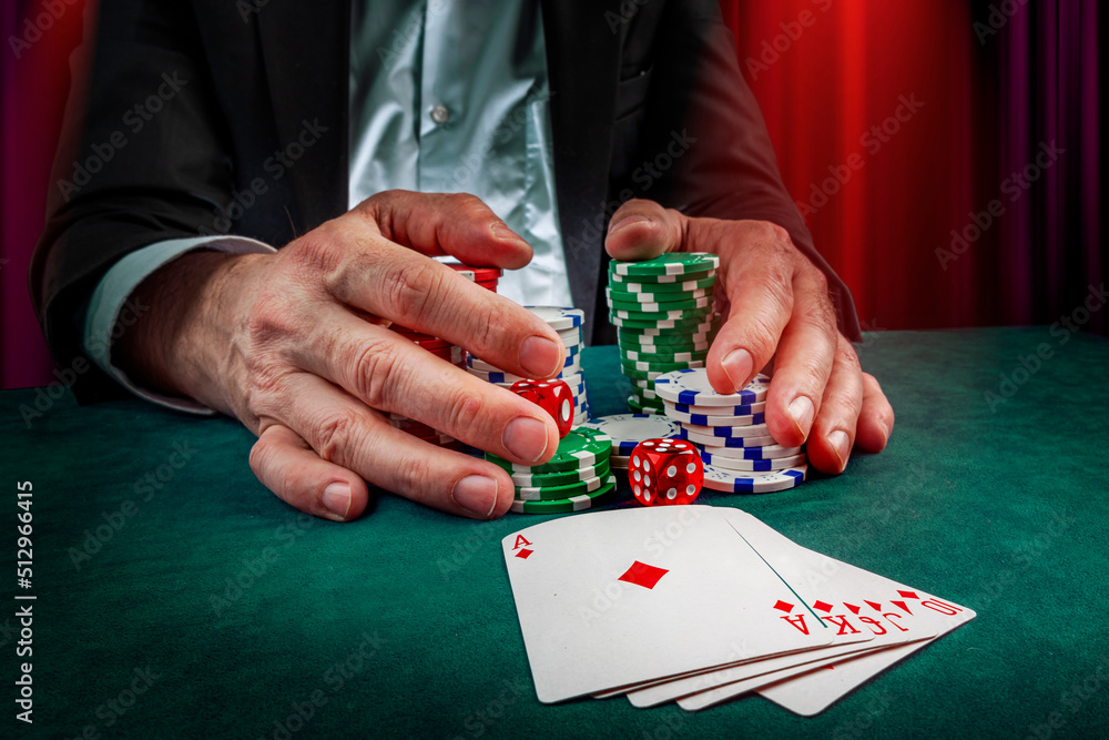 Gambling concept. Close up of male hand throwing dice at casino, gambling club. Сasino chips or Casino tokens, poker cards, gambling man spending time in games of chance Gambling concept. Close up of male hand throwing dice at casino, gambling club. Сasino chips or Casino tokens, poker cards, gambling man spending time in games of chance