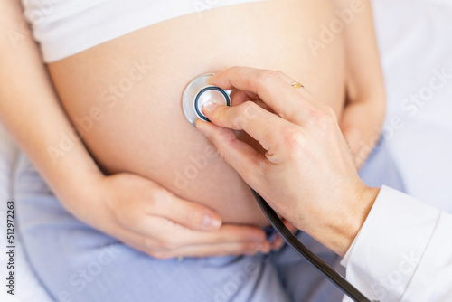 Pregnant doctor hospital. Medical clinic for pregnancy consultant. Doctor examining pregnancy woman belly holding stethoscope. Pregnancy, medicine health care concept.