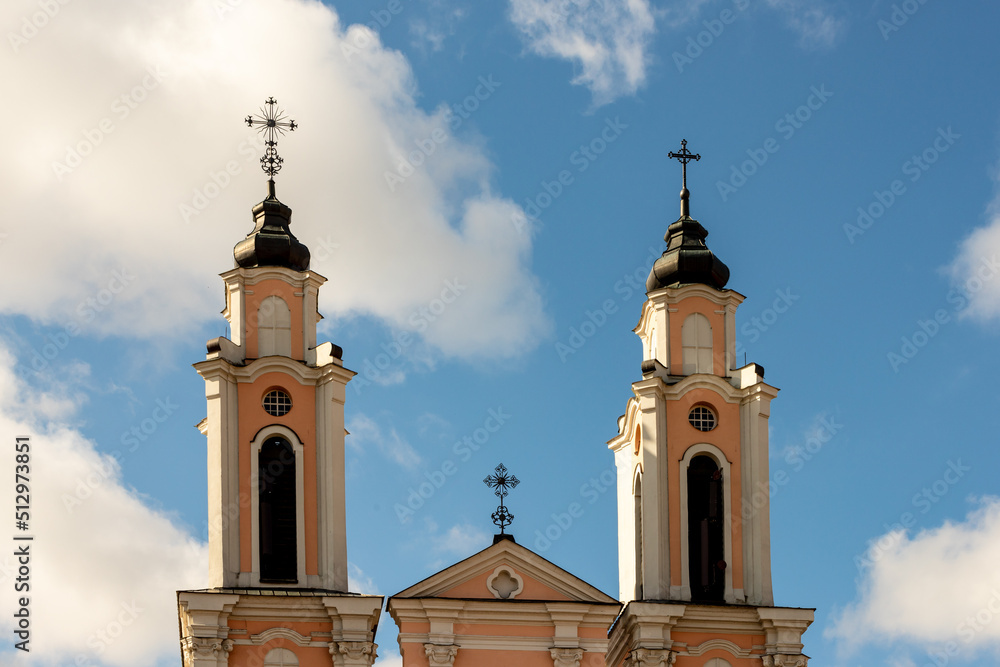 Church of the Holy Cross spires in Kaunas, Lithuania. Baroque white and orange colour bell towers at sky background. Roman Catholic Holy Cross church steeple.