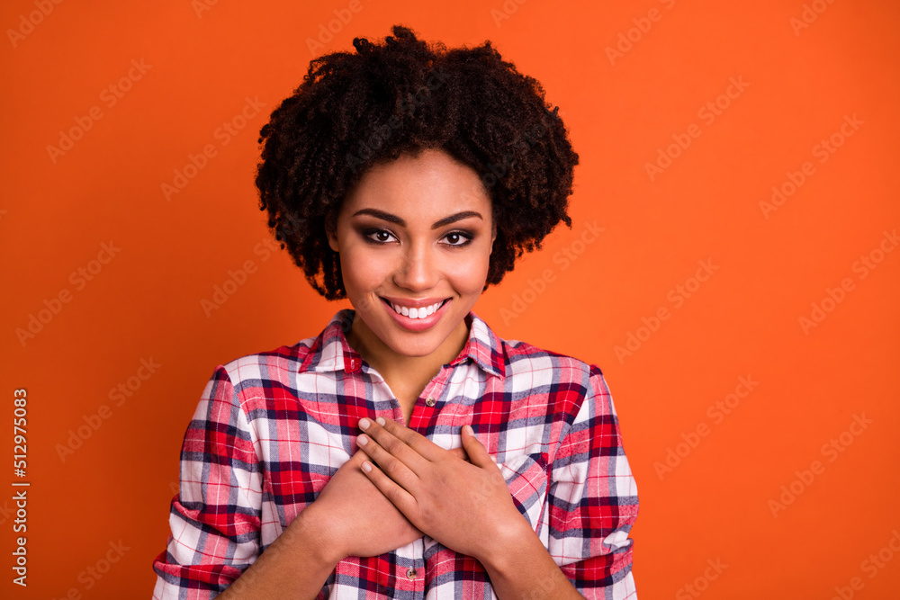 Photo of shiny adorable woman wear plaid shirt smiling arms chests empty space isolated orange color background Photo of shiny adorable woman wear plaid shirt smiling arms chests empty space isolated orange color background