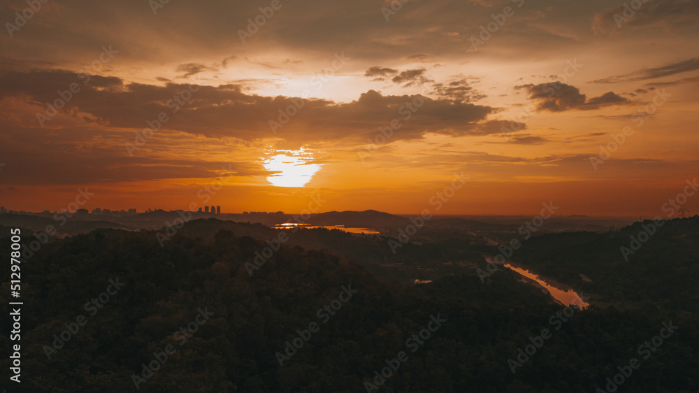 Amazing aerial view on the orange sky, sunset sun and clouds.