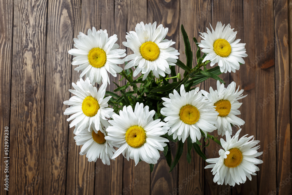 Obraz premium bouquet of daisies on a wooden background. copy space
