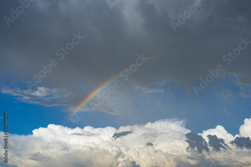 A rainbow arc across the sky during a rainstorm © jn14productions