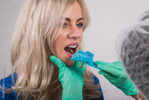 Fotografie dentist using dental impression tray on woman teeth