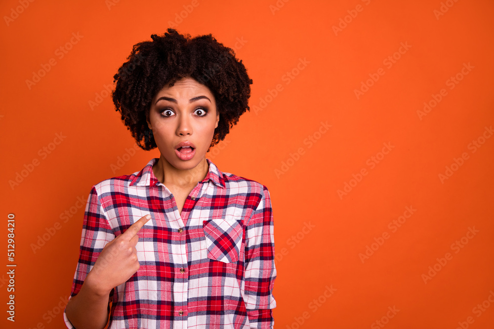 Photo of amazed pretty lady dressed checkered shirt pointing finger herself empty space isolated orange color background Photo of amazed pretty lady dressed checkered shirt pointing finger herself empty space isolated orange color background