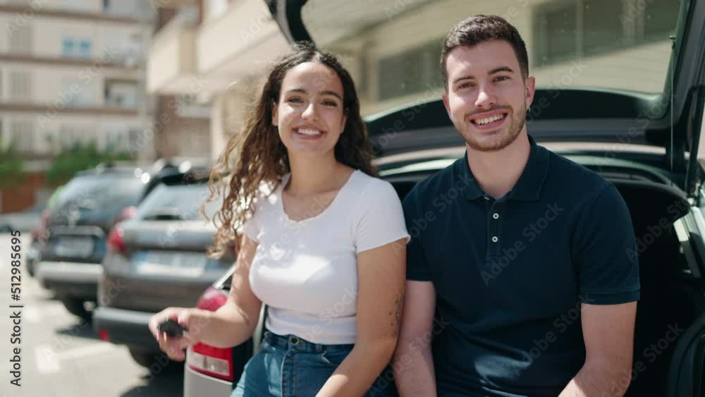 Young hispanic couple holding key of new car at street Young hispanic couple holding key of new car at street
