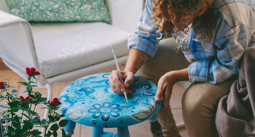 Foto Woman paiting and decorating furniture to renew and make home more beautiful