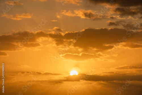 Golden sunrise sky with cumulus clouds and sun photo