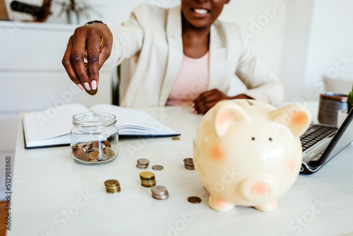 Foto Woman hand putting money coin into piggy for saving money wealth and financial concept