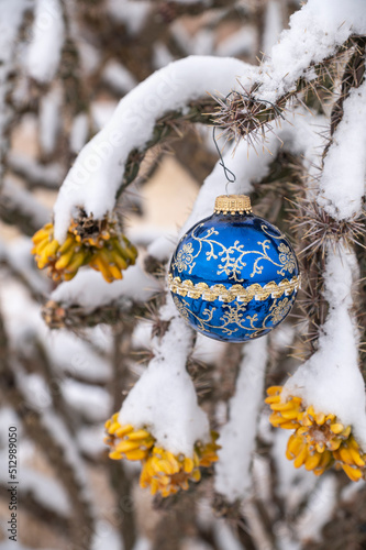 Close-up of Christmas ornament on snow covered cholla cactus photo