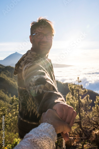 Woman hand pov perspective view of cheerful man enjoying the outdoor park leisuire activity - travel happiness and freedom concept with joyful beautiful couple together with love and friendship photo