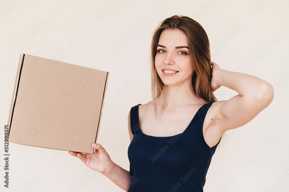 Girl in Black Dress Holds Cardboard Box in Her Hand Sideways. Caucasian Woman advertises box. Girl in Black Dress Holds Cardboard Box in Her Hand Sideways. Caucasian Woman advertises box.