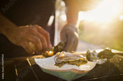 Man shucking fresh oysters photo