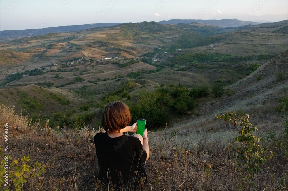 a man in nature in the hands of a phone with a screen for recording