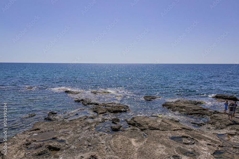 Small shallow sea creek with stones under the sun