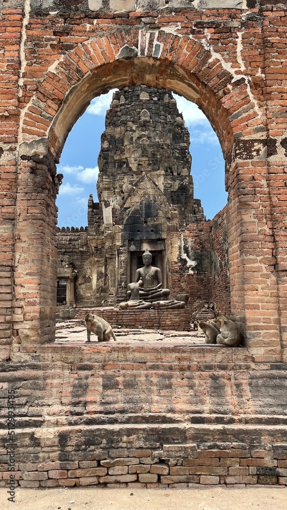 old Buddha statue with monkeys in Lopburi Thailand