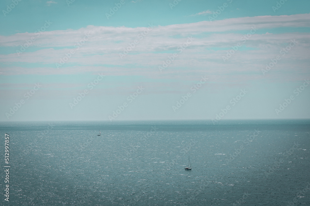 Sailing boat in a distance on open water. Mediterranean Sea with a blue sky Sailing boat in a distance on open water. Mediterranean Sea with a blue sky