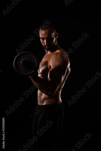 Portrait of guy lifting weights while being topless
