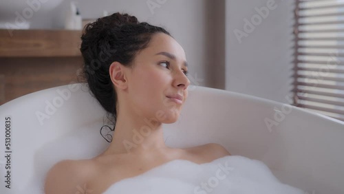 Close-up young attractive relaxed woman lying in hot foam bath with eyes closed resting relaxing in bathroom happy carefree pensive dreamy girl enjoying daily hygiene routine bathing washes bodycare
