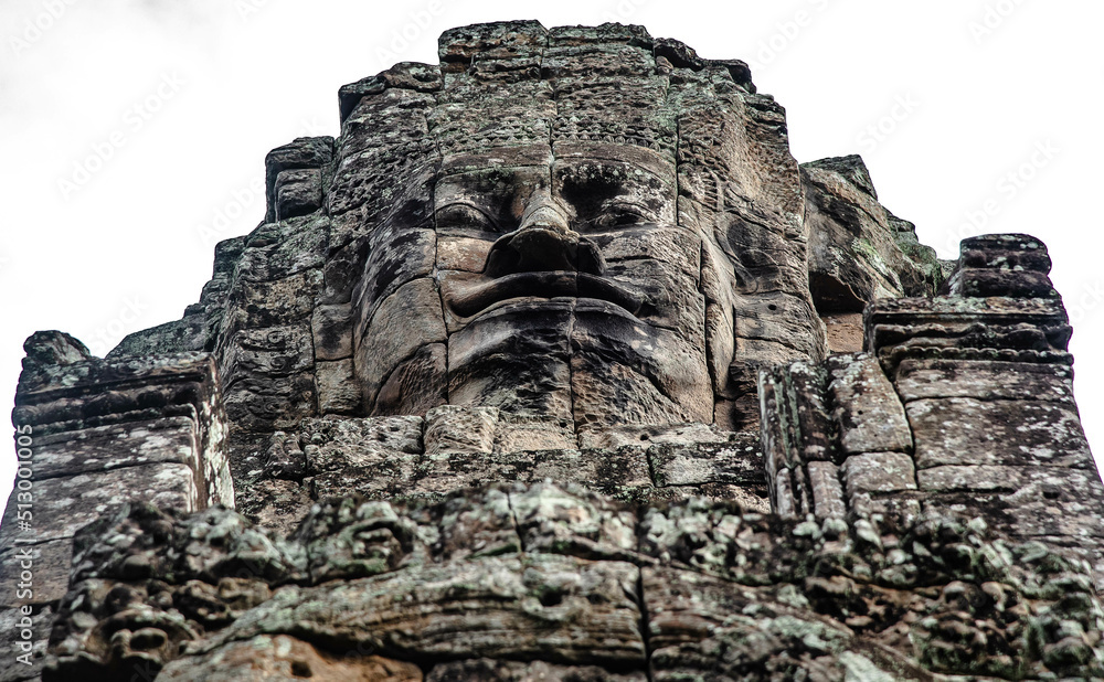 A large figure carved face on sandstone in the pagoda of Bayon Angkor Thom Temple, Siem Reap, Cambodia.