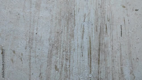 White wall with dirty spots. The texture of the concrete wall is white with scuffs. Painted concrete wall with plenty of cracks, holes and other defects.