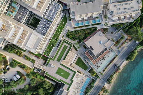 Aerial drone view of beautiful beach front hotel resort with swimming pool  umbrellas and turquoise sea. Paradise destination  Corfu  Greece. 