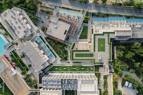 Aerial drone view of beautiful beach front hotel resort with swimming pool  umbrellas and turquoise sea. Paradise destination  Corfu  Greece. 