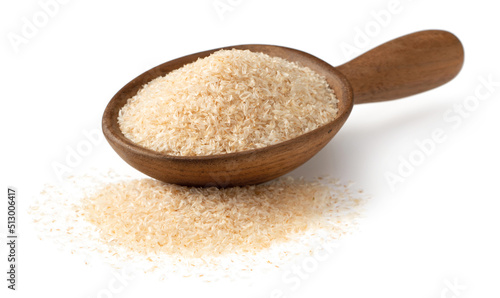 Psyllium husks in the wooden spoon, isolated on white background.