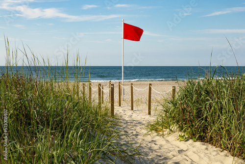 Red flag riptide warning on the beach photo