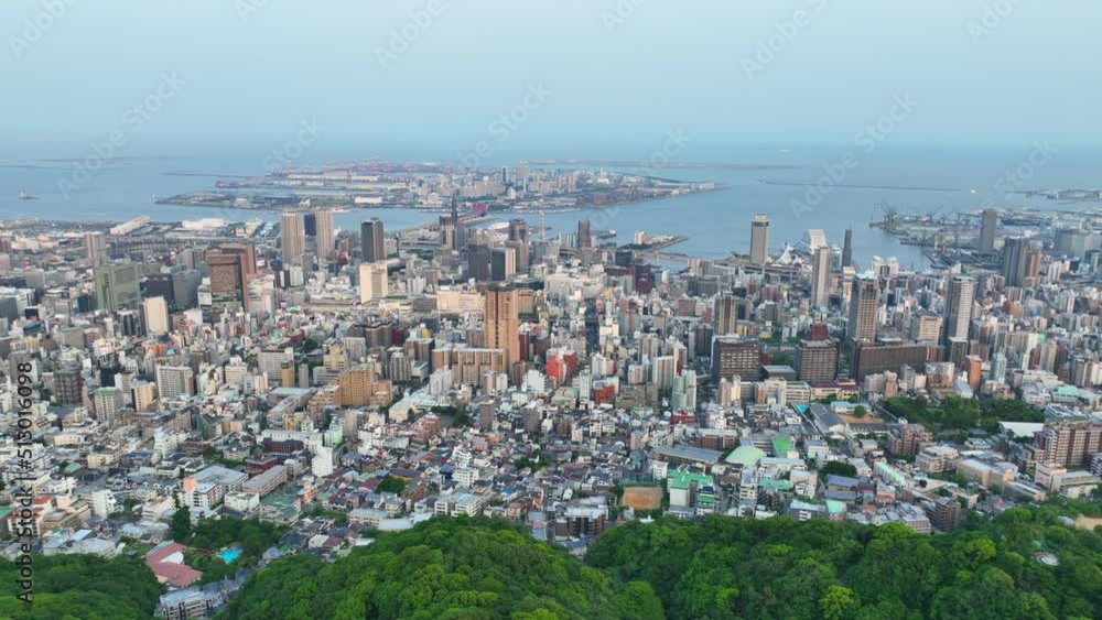 Slow aerial move over Mt. Rokko towards downtown Kobe and Port Island Slow aerial move over Mt. Rokko towards downtown Kobe and Port Island
