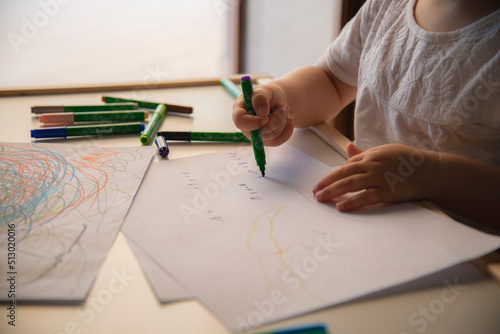 Kid drawing colorful shapes on white paper. Kids school education