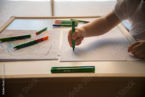 Little kid drawing on white paper