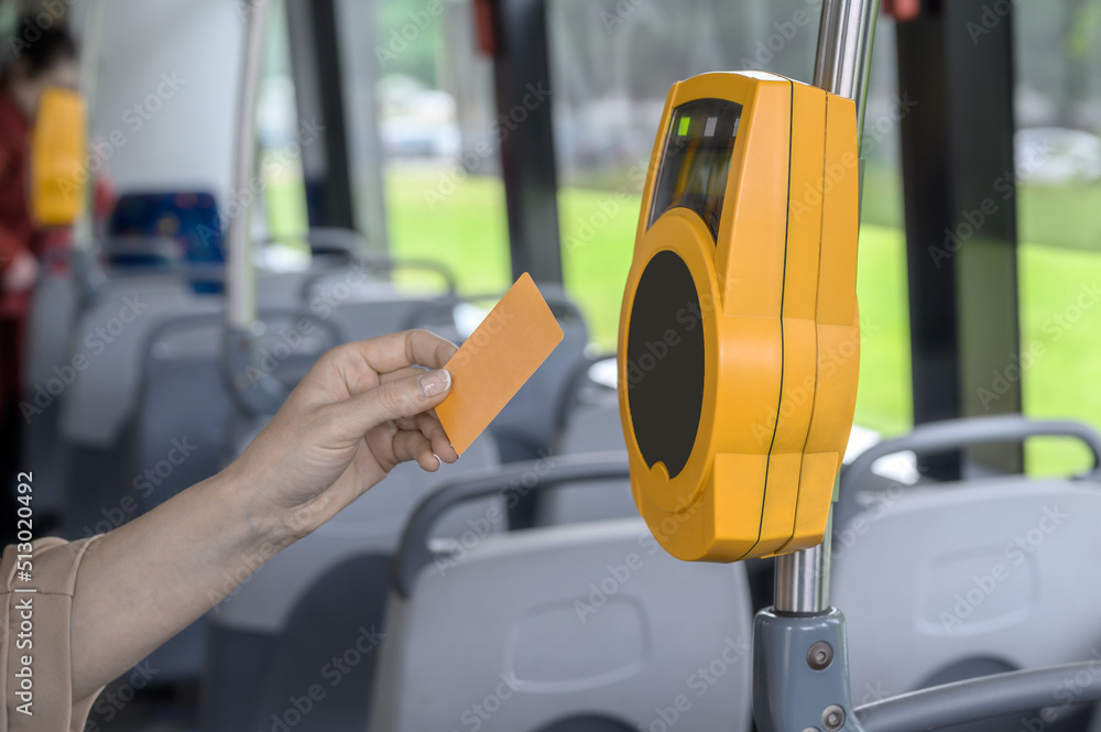 the passenger pays contactless with a bank card for public transport in the tram. the passenger pays contactless with a bank card for public transport in the tram.