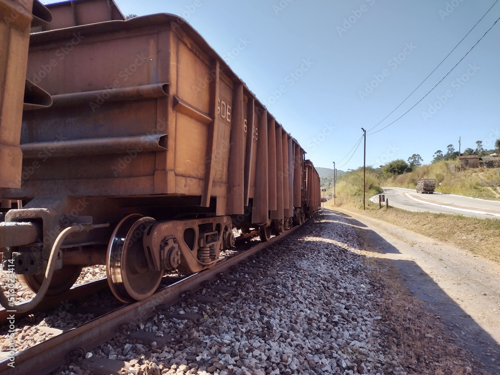 Landscape showing empty train cars above tracks with side road and clean blue sky background at Itabira Minas Gerais Brazil Landscape showing empty train cars above tracks with side road and clean blue sky background at Itabira Minas Gerais Brazil
