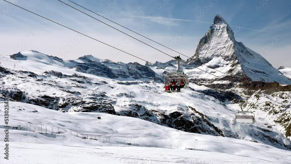 Beautiful footage of the famous Zermatt ski resort with the iconic Matterhorn peak in the alps in winter in Switzerland. People enjoying magical ski resort. 