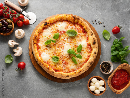 Pizza Margherita and ingredients on stone background
