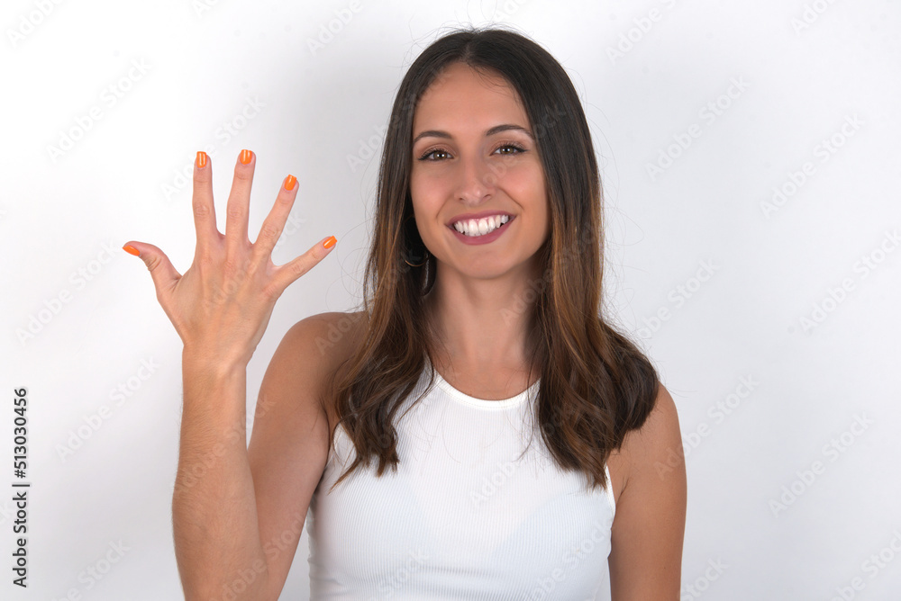 young beautiful caucasian woman wearing white Top over white background smiling and looking friendly, showing number five or fifth with hand forward, counting down young beautiful caucasian woman wearing white Top over white background smiling and looking friendly, showing number five or fifth with hand forward, counting down