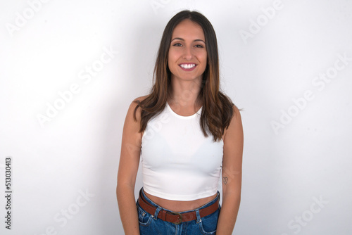 young beautiful caucasian woman wearing white Top over white background with nice beaming smile pleased expression. Positive emotions concept