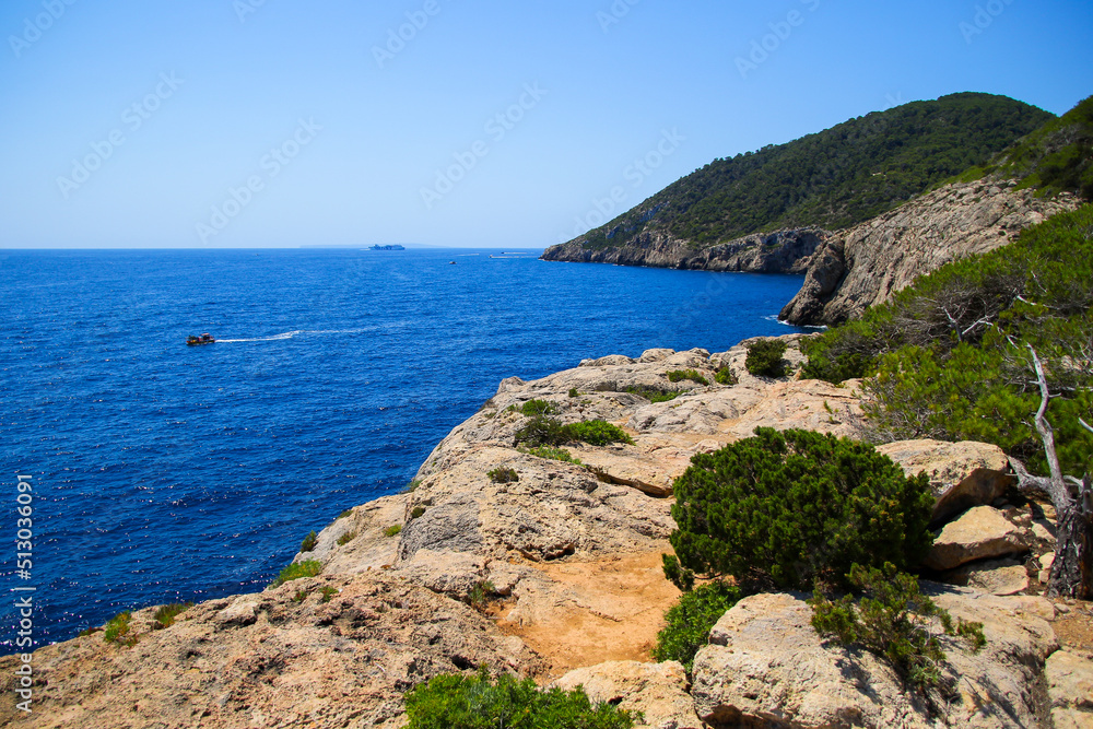 Rocky coastline near the mouth of the cove of Cala Llonga opening towards the Mediterranean Sea in the southeast of Ibiza in the Balearic Islands, Spain