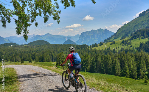 Fototapeta Naklejka Na Ścianę i Meble -  nice, active senior woman underway with her electric mountain bike in the Bregenz Wald near Dornbirn, VorarlbergAlps, Austria
