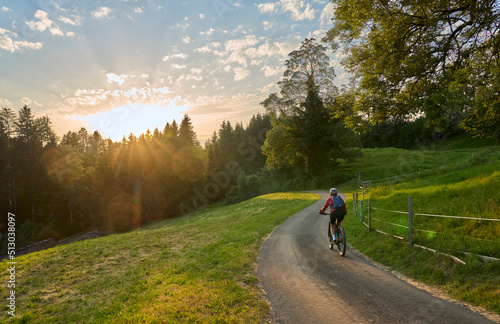 active woman riding her electric mountain bike at sunset in the Bregenz Forest mountains near Sulzberg, Vorarlberg, Austria  © Uwe