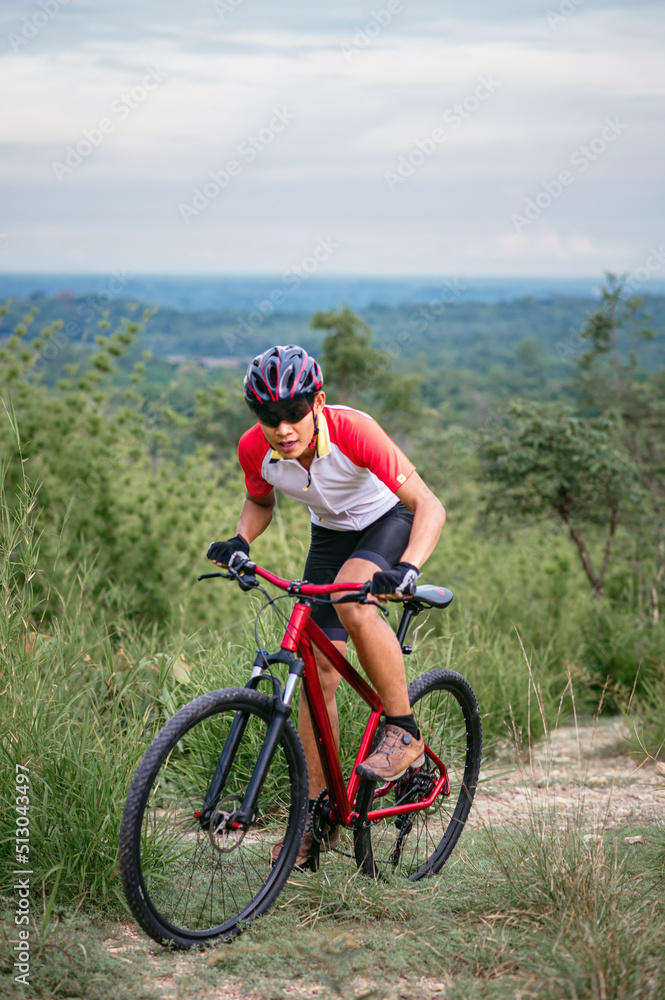 Mountain bikers ride MTB, mountain bike downhill to the extreme. Asian man rides MTB, mountain bike downhill in the wild to extremes. Extreme Sport and MTB, mountain bike downhill Concept.