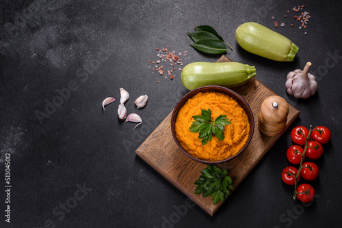Squash caviar with garlic and tomatoes in a rustic bowl on a dark background