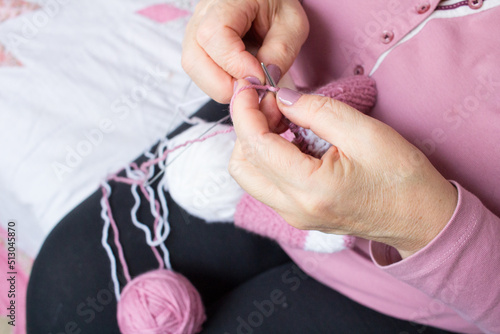 Process of yarn knitting by elderey woman  arms  spins  thread - close up