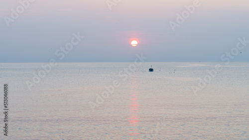 A fisherman drops his lobster pots just after sunrise off the coast of  Runswick Bay, North Yorkshire photo