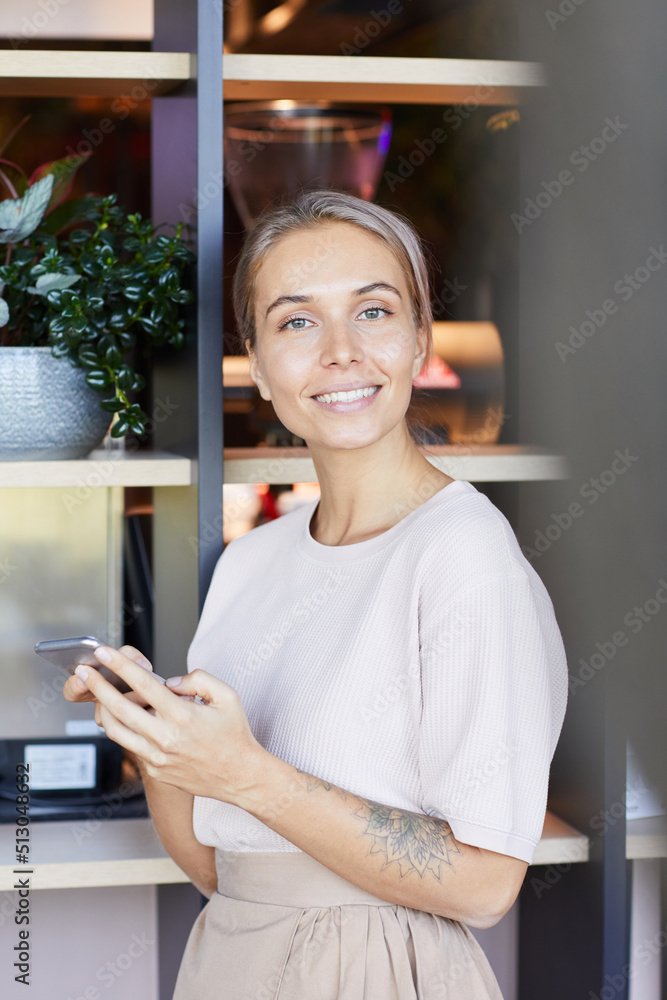 Portrait of cheerful beautiful young woman with tattoo on arm using modern phone while texting message Portrait of cheerful beautiful young woman with tattoo on arm using modern phone while texting message
