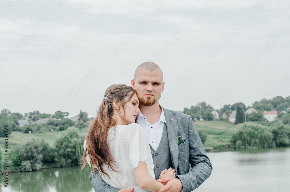 brides hugging on the background of the lake