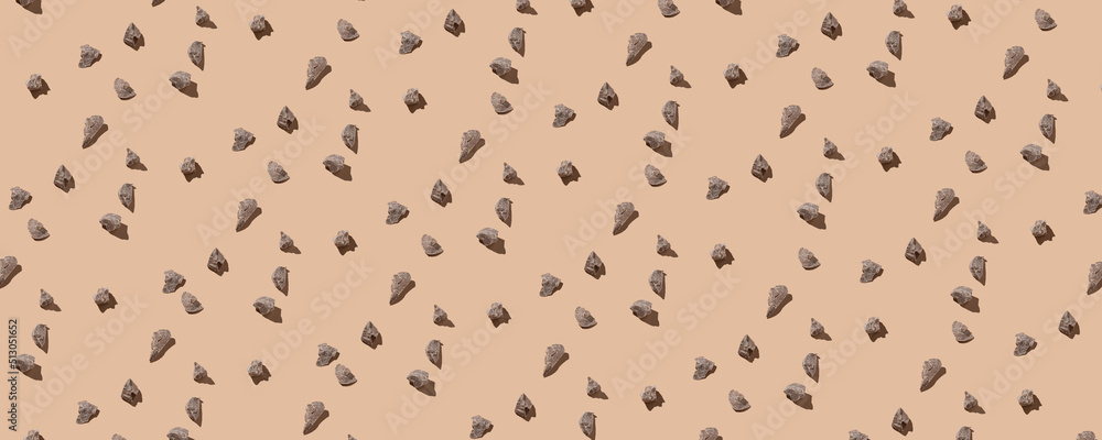 Random pieces of natural chocolate in a pattern on the beige pastel background. Top view of chocolate pieces. Continous pattern. Stevia, flat lay, hard light, minimal Random pieces of natural chocolate in a pattern on the beige pastel background. Top view of chocolate pieces. Continous pattern. Stevia, flat lay, hard light, minimal