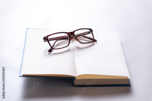 glasses on an open book, copy space, reading, myopic eyesight, education concept, selective focus